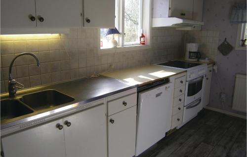 a kitchen with white cabinets and a sink at Two-Bedroom Holiday Home In Langaryd in Långaryd