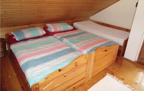 two beds in a cabin with wooden floors at Amazing Home In Weischlitz-ot Krbitz With Kitchenette in Taltitz