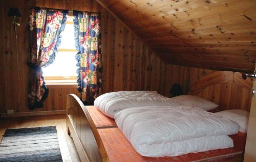 EvangerにあるNice Home In Evanger With 3 Bedroomsの木製の部屋にベッド2台が備わるベッドルーム1室