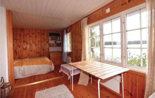 BrunskogにあるGorgeous Home In Brunskog With House Sea Viewのベッドルーム(テーブル、ベッド、窓付)