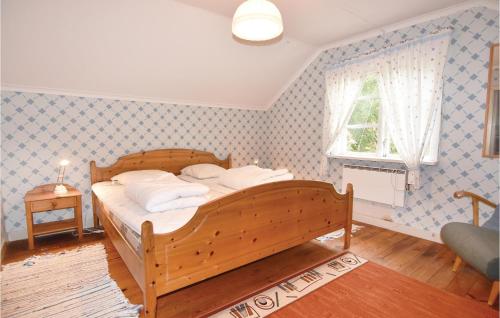 1 dormitorio con cama de madera y ventana en 2 Bedroom Pet Friendly Home In Molkom, en Sutterhöjden