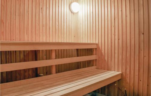 a sauna with wooden shelves and a light on the wall at Stunning Home In Hultsfred With Sauna in Hultsfred