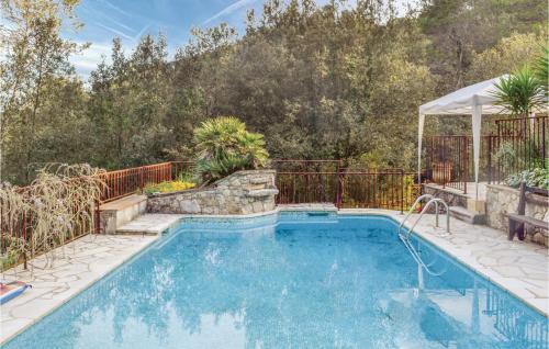 a pool in a backyard with a fence and trees at Awesome Home In La Roquette Sur Siagne in La Roquette-sur-Siagne