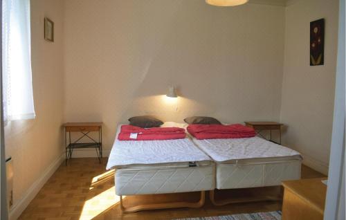 a bedroom with a bed with two red pillows on it at 3 Bedroom Beautiful Home In Lttorp in Löttorp
