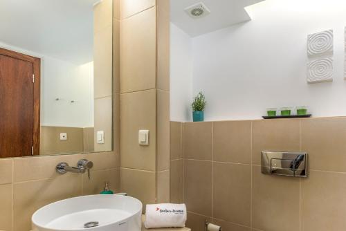 uma casa de banho com um WC, um lavatório e um espelho. em FLH Salgados Beach Apartment em Guia