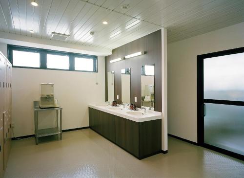 ein Badezimmer mit Waschbecken und großem Spiegel in der Unterkunft Hotel New Amami in Amami
