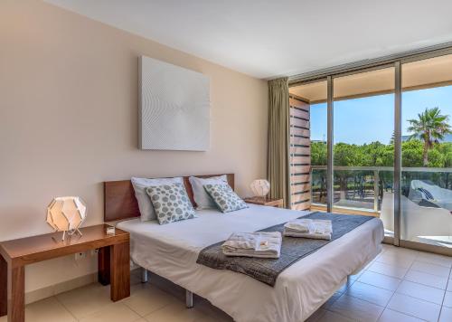 ein Schlafzimmer mit einem Bett und einem großen Fenster in der Unterkunft FLH Salgados Beach Apartment in Guia