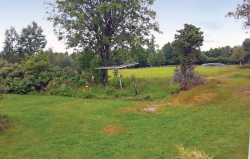 a field with a tree in the middle of it at Gorgeous Home In Vårgårda With Wifi in Vårgårda