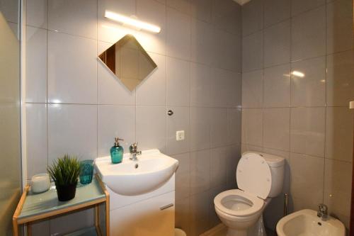bagno bianco con lavandino e servizi igienici di A Ilha do Lindo Vale a Porto
