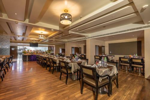 a dining room with long tables and chairs at Best Western Ramachandra in Visakhapatnam