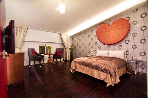 a hotel room with a bed with a heart on the wall at Formosa Vacation Village Homestay in Renai