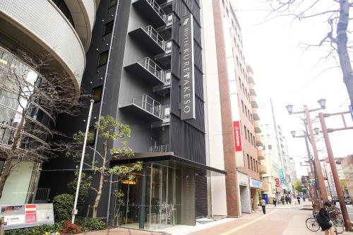 un bâtiment avec un panneau sur son côté dans l'établissement Hotel Kuretakeso Hiroshima Otemachi, à Hiroshima