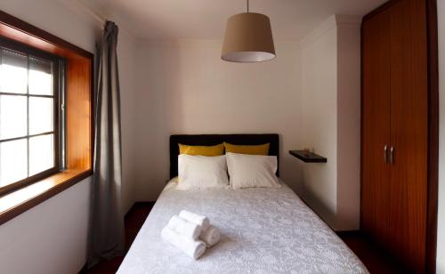 a bedroom with a bed with two towels on it at A Ilha do Lindo Vale in Porto