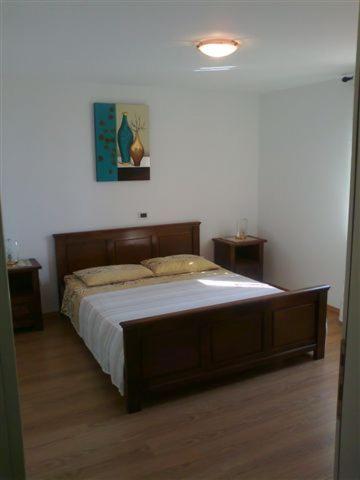 a bed in a bedroom with two night stands at Apartments Edo in Novigrad Istria