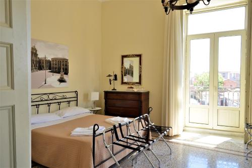 a bedroom with a bed and a large window at B&B al Teatro Massimo in Catania