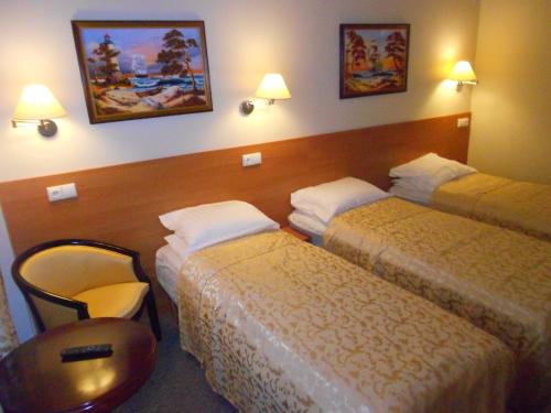 a hotel room with two beds and a chair at Silvija House in Vilnius