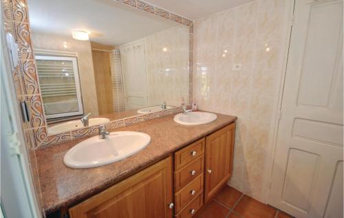 a bathroom with two sinks and a large mirror at Amazing Home In Bagard With 3 Bedrooms, Wifi And Outdoor Swimming Pool in Bagard