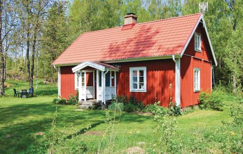 a red house with a red roof in a field at Holiday Home Knihult Häradsbäck in Knihult