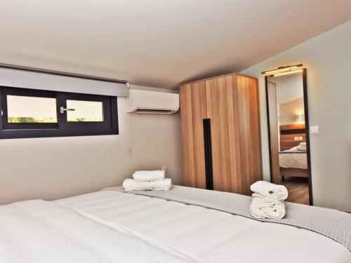 a bedroom with a bed with towels on it at Notos Resort - Tristinika Sithonia in Toroni