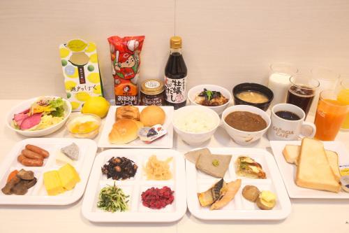 a table with several plates of food and drinks at Hotel Kuretakeso Hiroshima Otemachi in Hiroshima