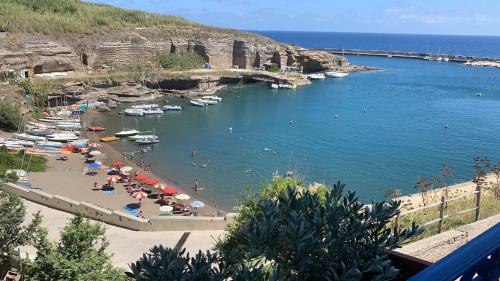 a beach with a bunch of people and boats in the water at Hotel Isolabella in Ventotene