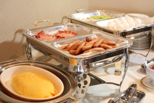 a buffet with hot dogs and other food on a table at Hotel Osaka Castle in Osaka