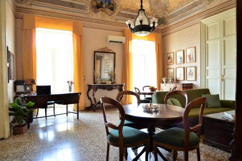 sala de estar con mesa, sillas y piano en B&B al Teatro Massimo, en Catania