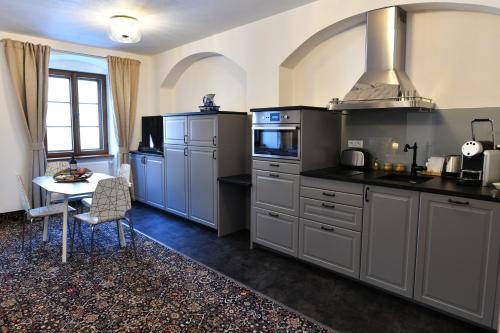 a kitchen with gray cabinets and a table in it at Bed&Bike Prachatice in Prachatice