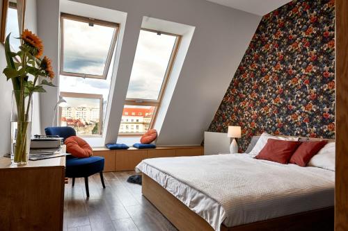 1 dormitorio con 1 cama grande y cabecero de flores en Don Kichot Apartment, en Wroclaw