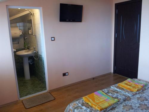 a bathroom with a bed and a sink and a mirror at Guest House Emi in Balchik