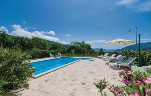 a swimming pool with chairs and an umbrella at Cozy Home In Igalo With Wifi in Herceg-Novi