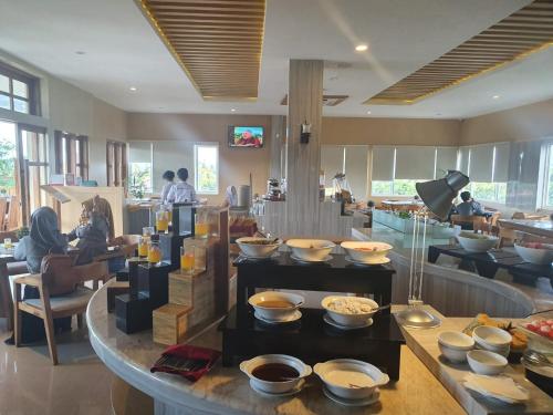 a restaurant with a bunch of bowls on display at Luminor Hotel Banyuwangi By WH in Banyuwangi