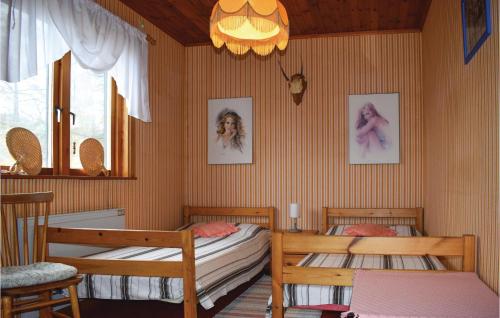 Ankarsrum的住宿－Cozy Home In Ankarsrum With Lake View，一间卧室配有两张单人床和吊灯。