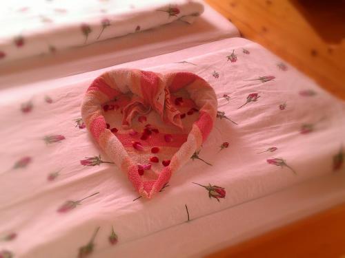 a heart on a bed covered in lady bugs at Schlosserhof in Telfes im Stubai