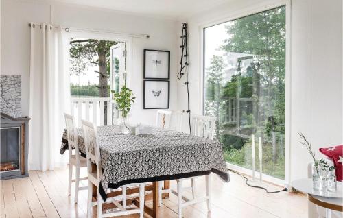 ein Esszimmer mit einem Tisch, Stühlen und einem Kamin in der Unterkunft 3 Bedroom Cozy Home In Bodafors in Bodafors