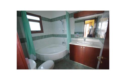 a bathroom with a tub and a toilet and a sink at Amazing Home In Pegia-paphos With 3 Bedrooms, Wifi And Outdoor Swimming Pool in Peyia
