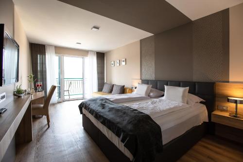 a bedroom with two beds and a desk and a television at Gostilna in motel Pri Lešniku in Maribor