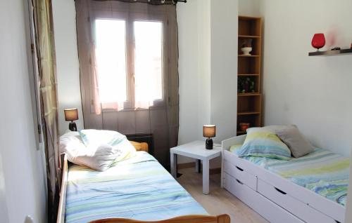 two beds in a small room with a window at Beautiful Home In Marsillargues With 3 Bedrooms, Private Swimming Pool And Outdoor Swimming Pool in Marsillargues