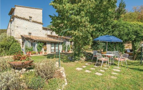 a table and chairs with an umbrella in a yard at Casale Petrucci in Vacone