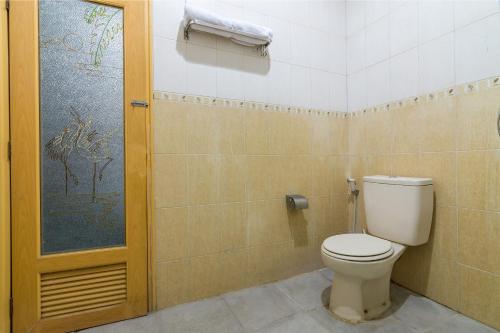 a bathroom with a white toilet in a room at RedDoorz near Tugu Yogyakarta in Yogyakarta