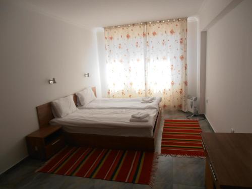 a small bedroom with a bed and a window at Monastery 3 Apartments TMF in Pamporovo