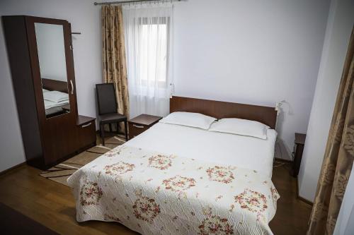 Un pat sau paturi într-o cameră la Pensiunea Lucian