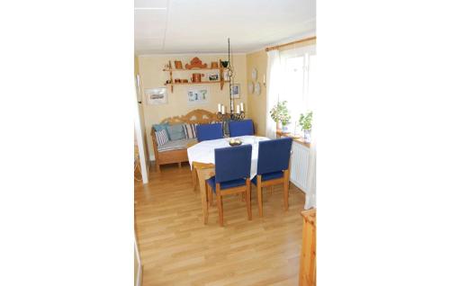 a dining room with a table and blue chairs at Awesome Home In Sölvesborg With Kitchen in Hällevik