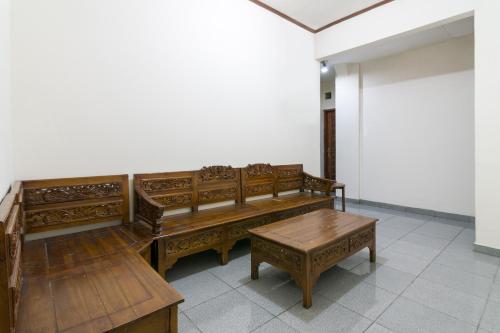 a room with wooden benches and a table at RedDoorz near Tugu Yogyakarta in Yogyakarta