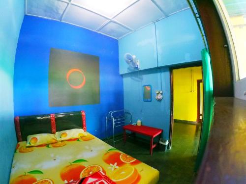 a blue room with a bed and a red chair at Olivia homestay in Banyuwangi