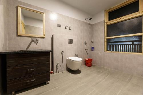 ein Badezimmer mit einem WC, einem Waschbecken und einem Spiegel in der Unterkunft HITCHHIKERS HOSTEL LADAKH in Leh
