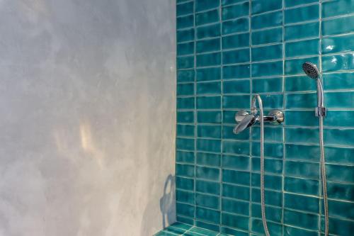 une douche carrelée de bleu avec un pommeau de douche. dans l'établissement LovelyStay - Traditional Alfama View, à Lisbonne