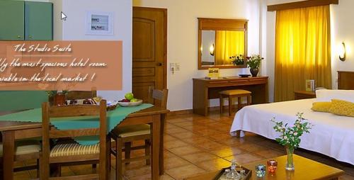 a room with a bed and a table and a kitchen at Sissy Village All Suite Hotel in Kounoupidhianá