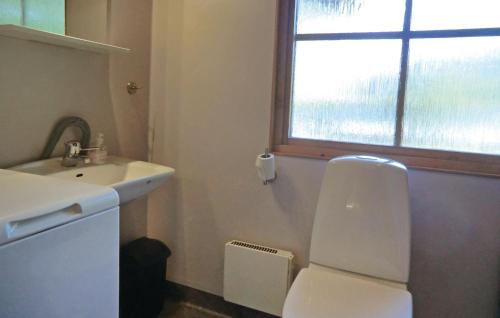 baño con aseo y lavabo y ventana en Cozy Home In Frjestaden With Kitchen en Vanserum