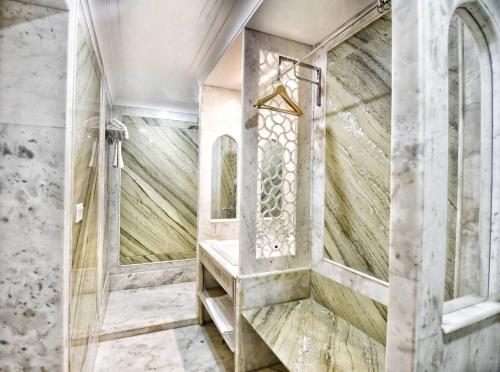 Un baño con ducha con pared de piedra. en Nirbana Palace - A Heritage Hotel and Spa, en Jaipur